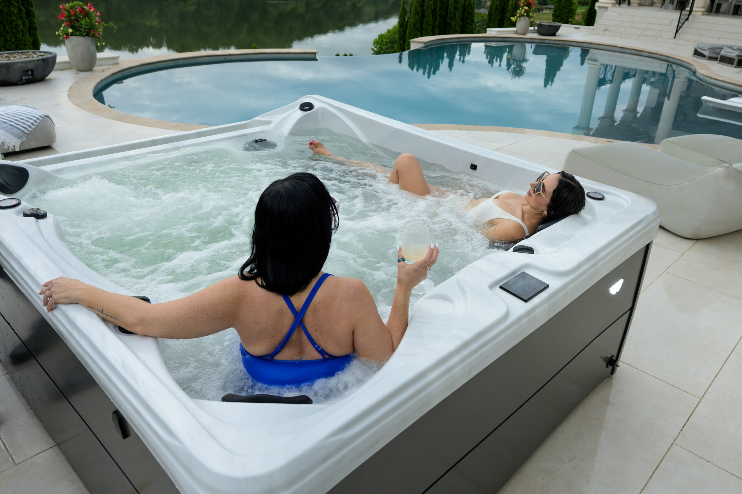 Two friends are relaxing in the Harmony, a Whisper Spa's flagship model hot tub.